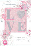 The anniversary card in this image is a gentle tribute to enduring romance, echoing the hush of a private celebration in a quiet corner of Hendon. At its centre, the word "LOVE" is written in bold, raised letters, each one edged with a soft halo of glitter that shifts between silver and pearl. The letter "O" has been transformed into a shimmering heart, slightly more textured than the rest, drawing the eye and inviting a tender touch. The colour palette surrounding this focal point blends pastel pinks with cool, silvery greys, creating an intimate, almost velvety backdrop. Delicate blooms in blush and mauve seem to unfold around the central word, their watercolor softness giving them a dreamy, romantic quality. Petals stretch outward, stems curve gently, and trailing leaves provide a sense of graceful movement, like a bouquet captured in stillness. Tiny decorative touches-swirling flourishes, scattered petals, and subtle butterflies-add a light, whimsical note, reminiscent of an English spring garden tucked behind Hendon's residential streets. Above and below the floral display, words such as "On Our Anniversary" and "I love you today and always" appear in a refined, flowing script that feels handwritten and sincerely meant. The overall composition is calm and harmonious, with enough open space to let each element breathe. It feels like a keepsake chosen as carefully as a bespoke anniversary arrangement from a local Hendon florist, designed to mark a shared journey that is soft-spoken yet deeply heartfelt.